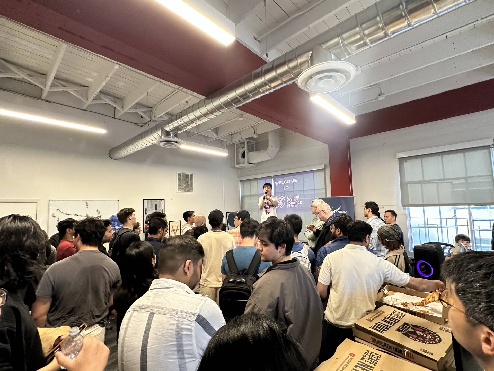 Researchers demonstrating a robotic arm at a community event
